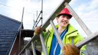 young worker carrying a ladder