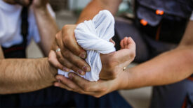 worker tends to coworker's hand injury